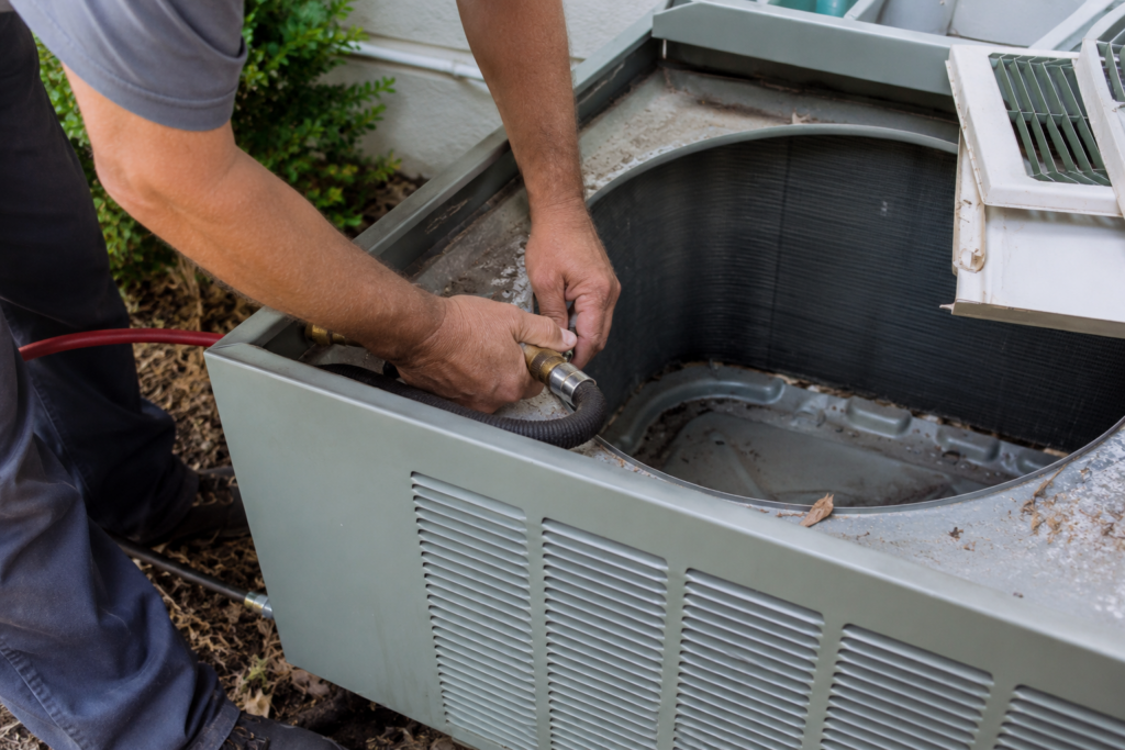 HVAC technician inspecting an air conditioner affected by AC warranty maintenance mistakes